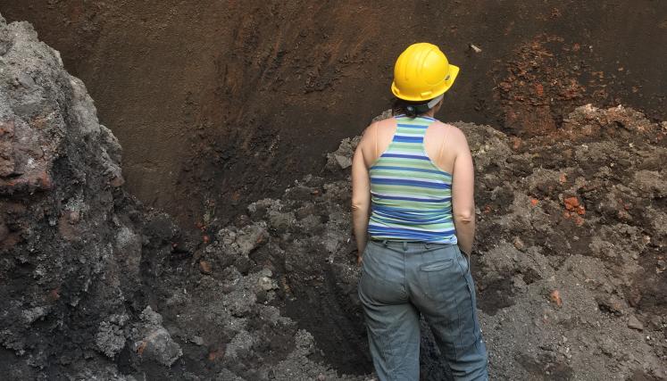 Mujer de espaldas en una excavacion arqueologica 